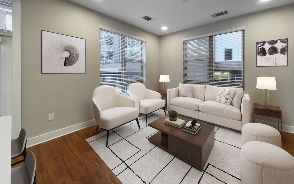 Furnished apartment living area with white couches, four large windows, and vinyl plank flooring