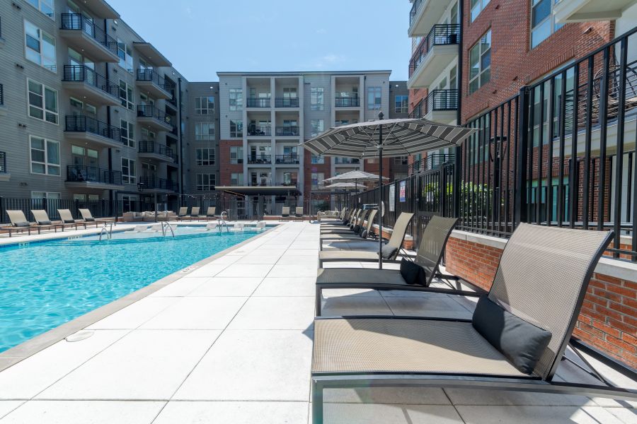 Van Alen apartments resort-inspired pool with in-pool lounge seating and surround lounge chairs and umbrellas
