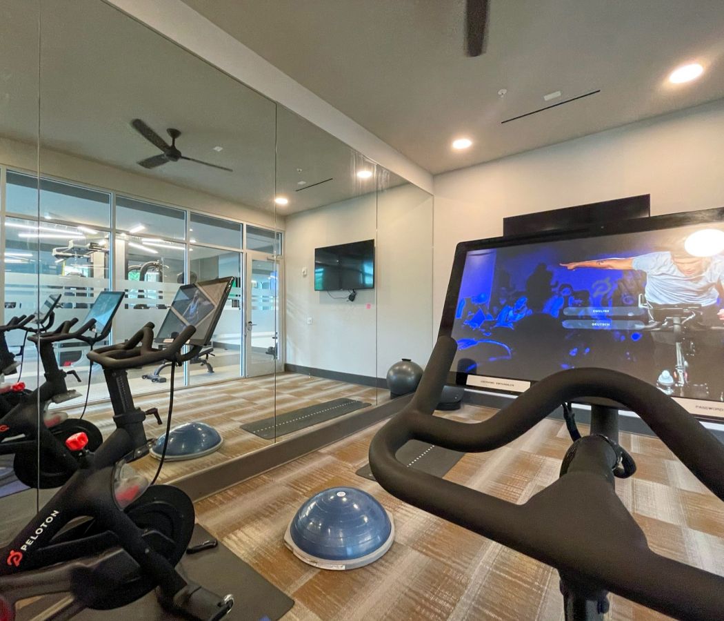 Van Alen apartments resident amenity fitness studio with Peloton bikes and yoga space