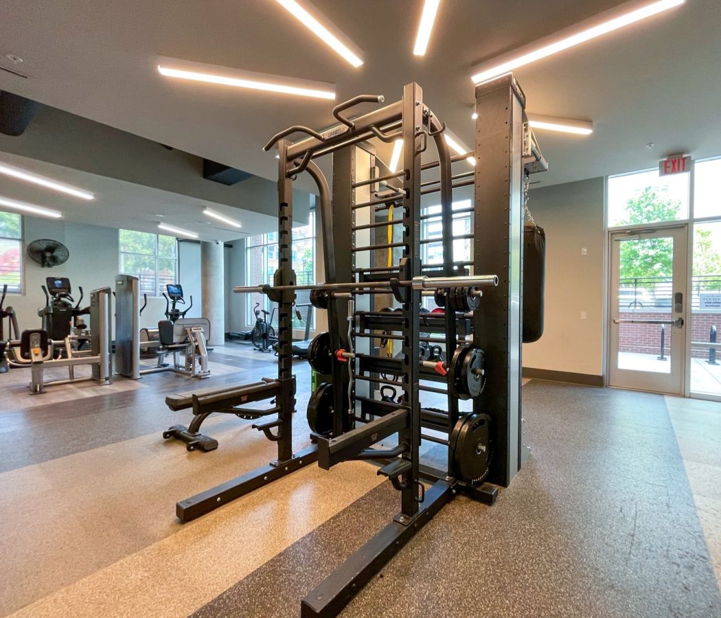 Van Alen community amenity fitness center with bar bell weights and cardio machines