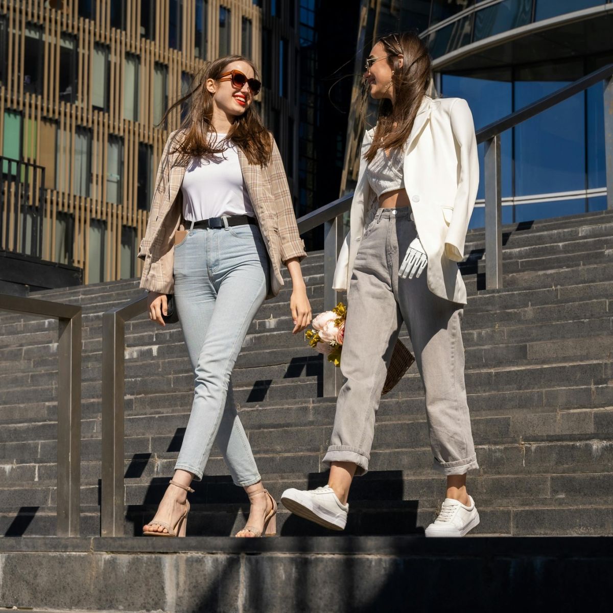 Young women in business casual attire walking down city stairway