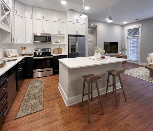 Van Alen apartments in Downtown Durham NC bright kitchen with custom cabinets, designer pendant lights, and kitchen island