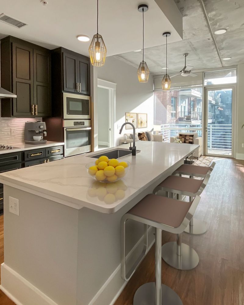 Van Alen apartments in Downtown Durham NC modern kitchen with large island and balcony off the living room