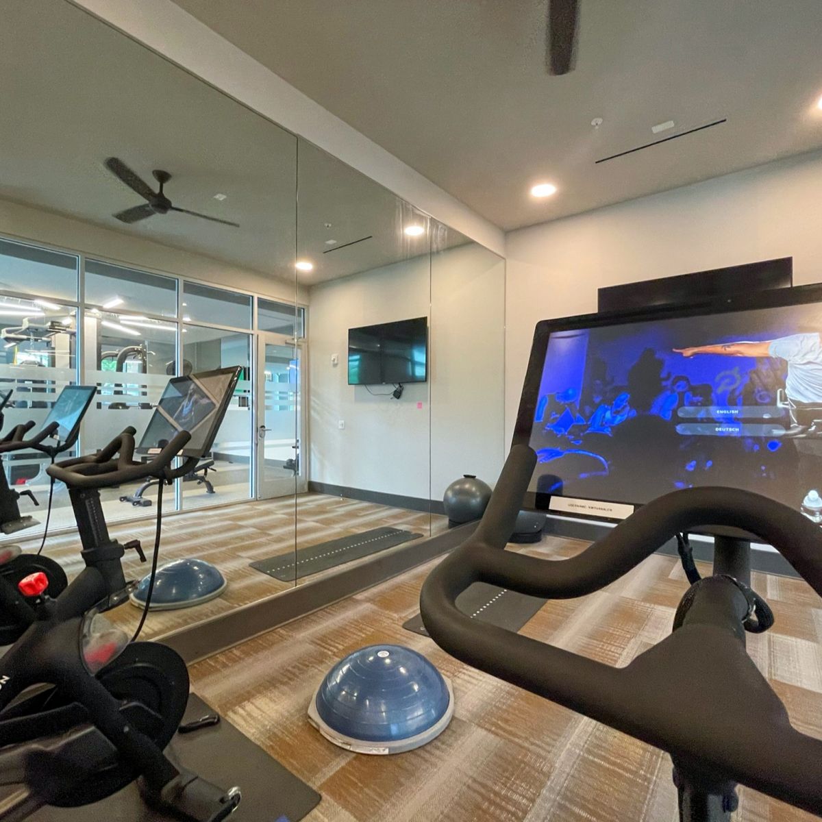 Van Alen apartments resident amenity fitness studio with Peloton bikes and yoga space