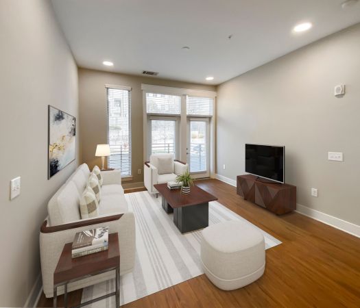 Van Alen Plaza apartment living room with large windows and balcony access