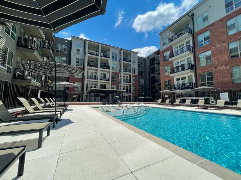 Van Alen apartments resort-inspired pool with in-pool lounge seating and surround lounge chairs and umbrellas